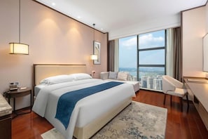 A hotel room with a large bed, a desk, a chair, a view of the city, and a large window. - Yamei Hotel (Xiangtan Youyi) (Xiangtan)