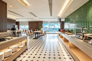 A modern kitchen with a long counter, dining area, and a view of the city. - Yamei Hotel (Xiangtan Youyi) (Xiangtan)