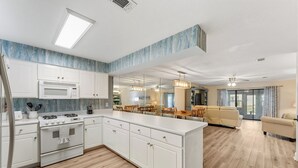 A modern kitchen with white cabinets, a built-in microwave, and a gas stove. - Townhome Steps to the Beach · Resort Pool & Courts (Panama City Beach)