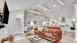 A spacious living area with a sofa, a coffee table, and a television. - Stylish Cozy Cottage in East~10 min. to Broadway (Nashville)