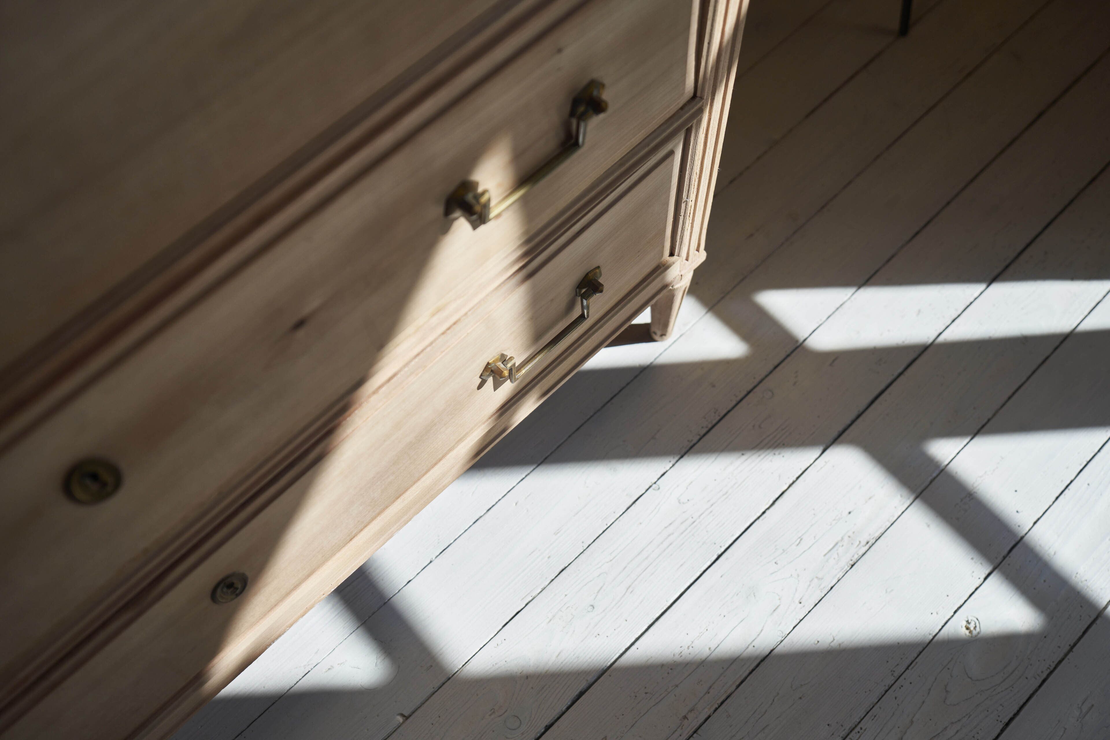 A wooden dresser with drawers and a metal handle.