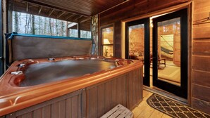 A wooden cabin with a hot tub, stone walls, and a view of the forest. - Storybook Hideaway, where memories that fill your heart with comfort, gladness a (Blue Ridge)