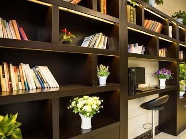 A bookshelf with books and potted plants. - GreenTree Hotel (Rugao Zhongjiao Meilucheng) (Rugao)