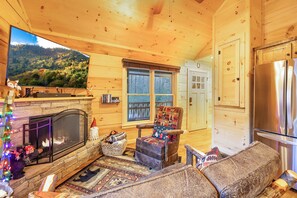 Cozy cabin with a fireplace, scenic forest view, and comfortable seating area.