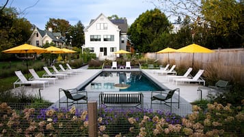 Una piscina al aire libre de temporada, sombrillas