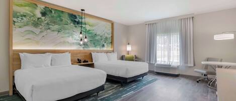 A hotel room with two beds, a large abstract painting, a desk, and a chair.