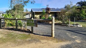 Un alojamiento vacacional llamado COOLA STUDIO, con entrada privada con cerramiento, paneles solares en el techo y diversa vegetación circundante.