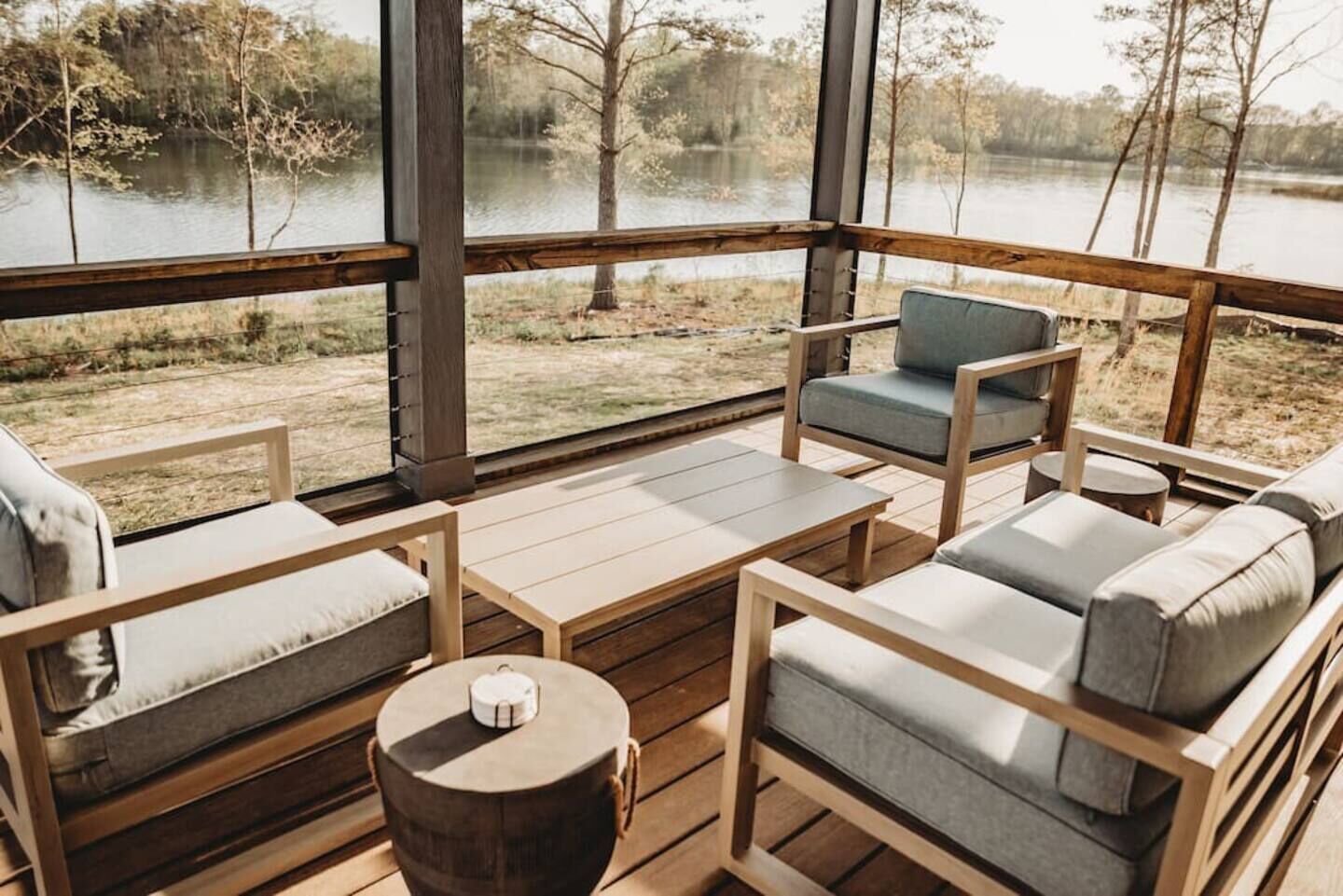 A wooden deck with seating and a view of a lake.