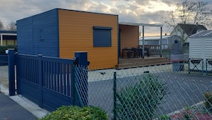 Una casa moderna con fachada de madera, patio cercado y zona de patio.