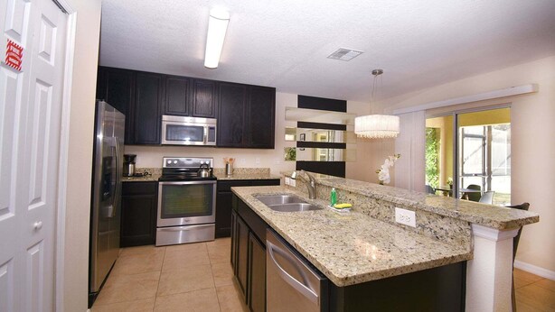 Una cocina moderna con electrodomésticos de acero inoxidable, encimeras de granito y una isla grande.