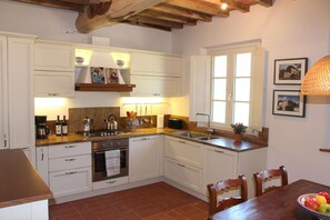 Enjoy cooking in this well-equipped kitchen with a stove, sink, and dining area.