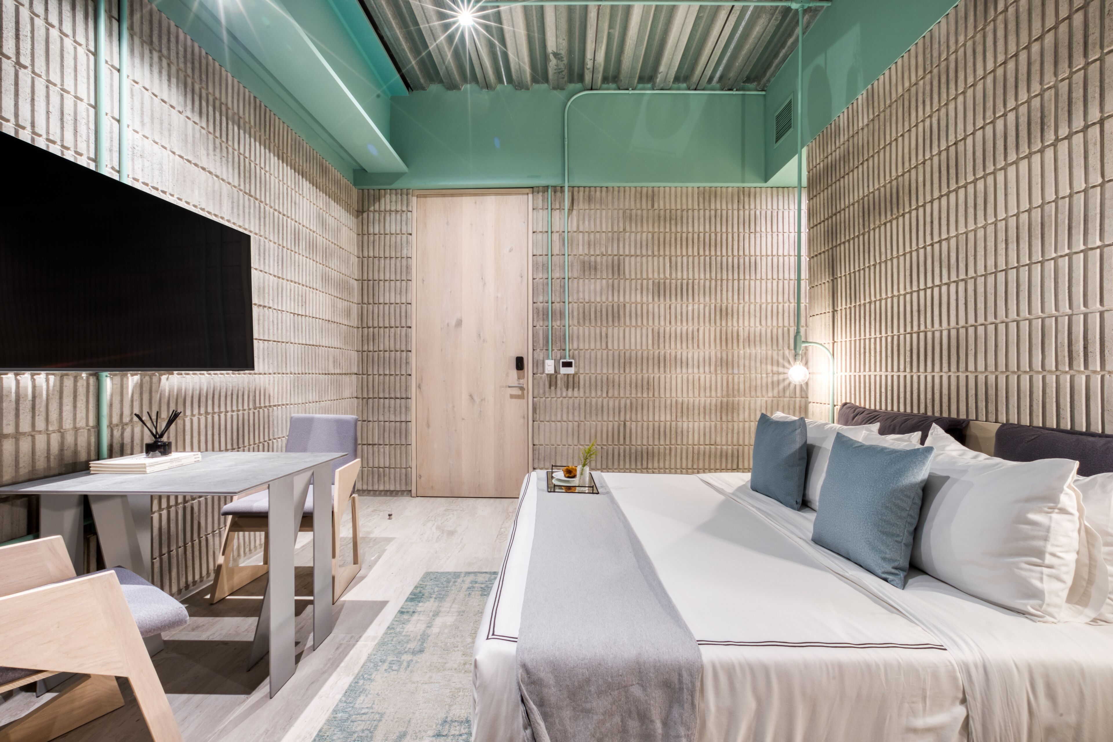 Et moderne hotelværelse med en stor seng, et skrivebord og et fjernsyn.