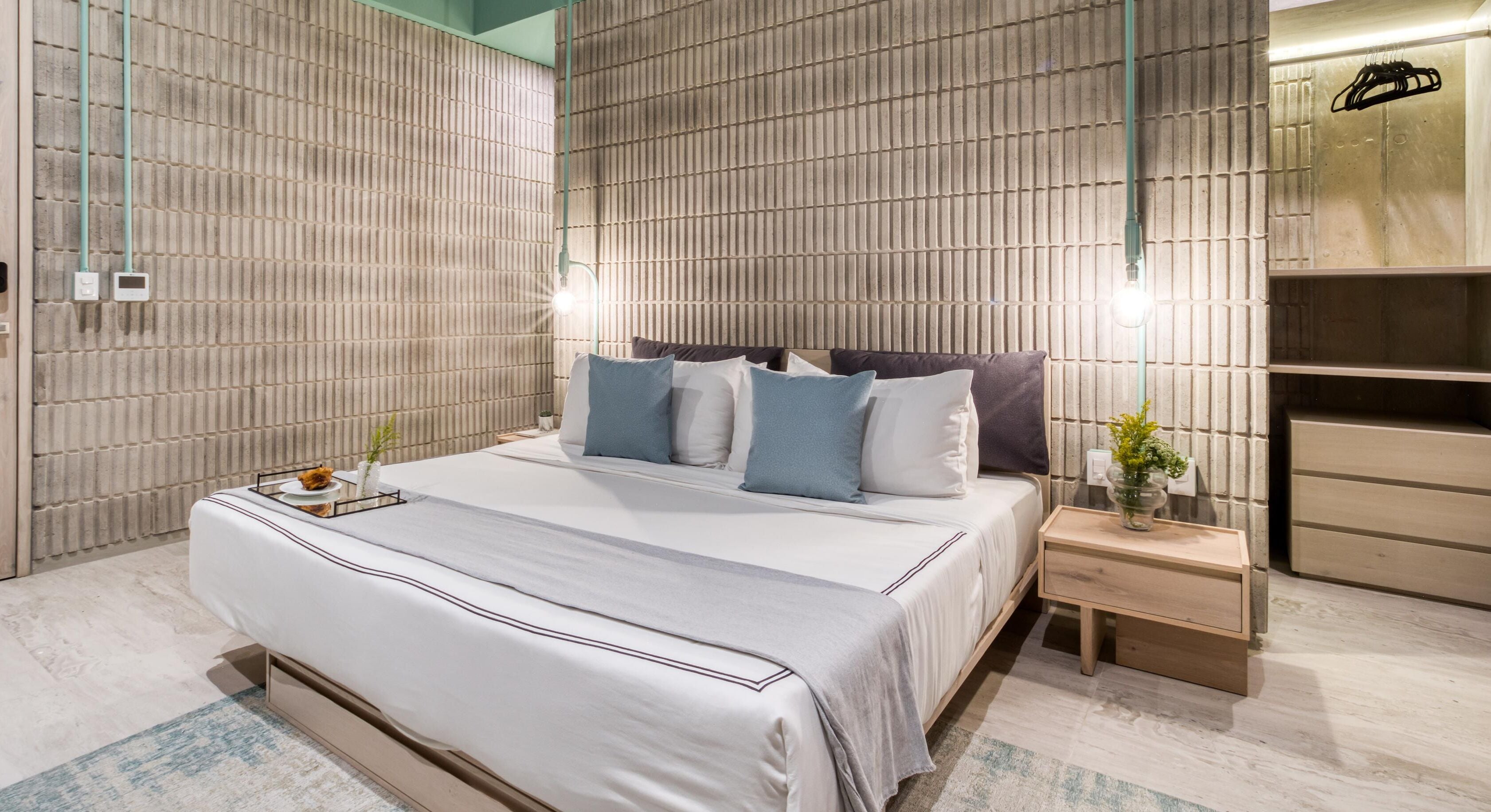 Ein modernes Schlafzimmer mit einem großen Bett, Nachttischen und einem eingebauten Kleiderschrank.
