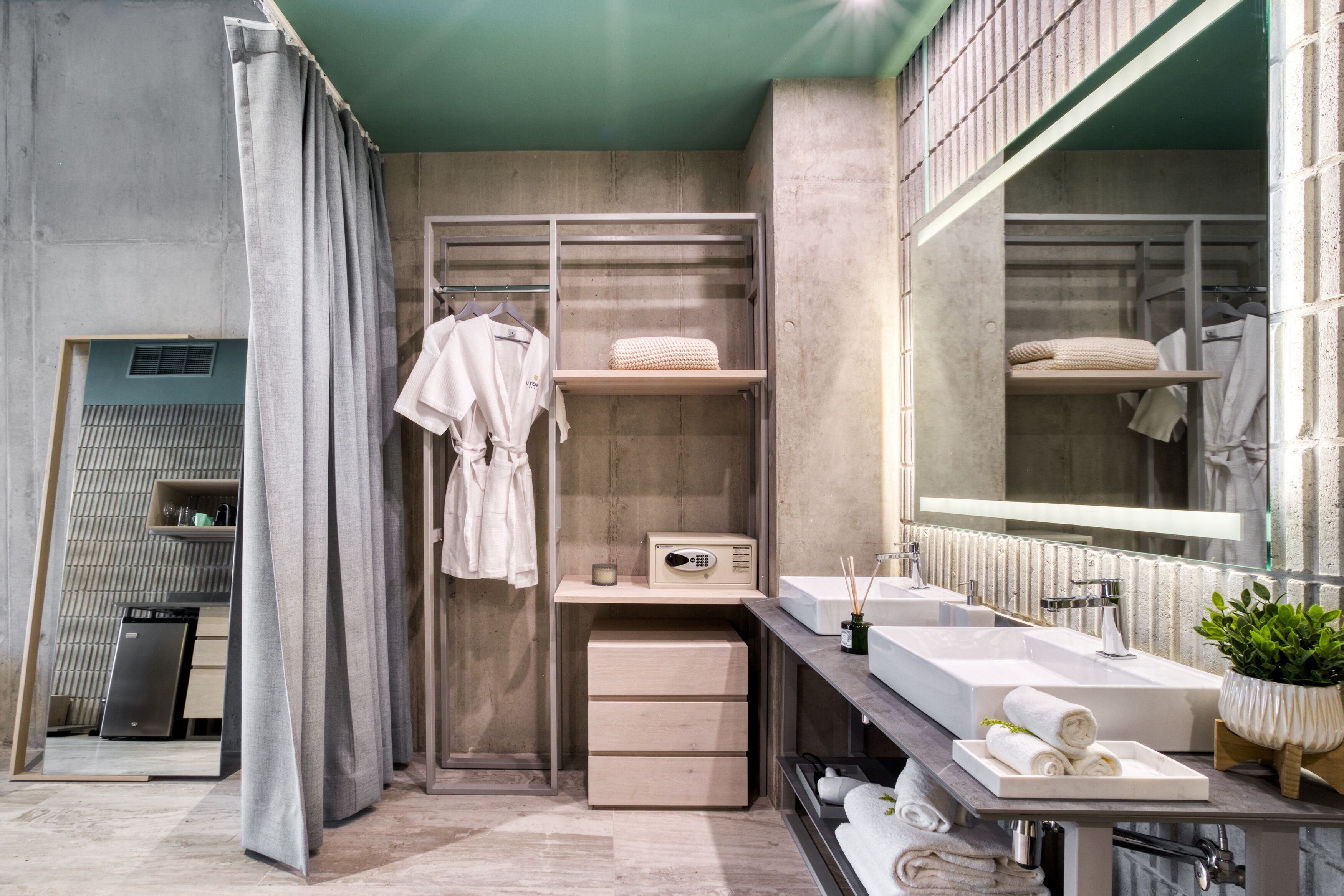A modern bathroom with a large mirror, dual sinks, a towel rack, and a built-in radio.
