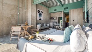 Una habitación de hotel moderna con una cama grande, un comedor y una kitchenette.