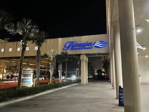 The exterior of the Tideland Beach Resort with a prominent sign, palm trees, and a paved walkway leading to the entrance.