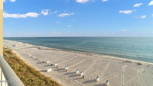 A beach with a clear sky, a calm sea, and a long pier extending into the water. - Super clean, lower level, recently renovated and beachfront - walk to Pier Park (Panama City Beach)