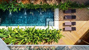 A rooftop pool with a wooden deck, lounge chairs, and potted plants. - Caribbean Courtyard | Luxury Jungle Villa w Pool (Puerto Viejo de Talamanca)