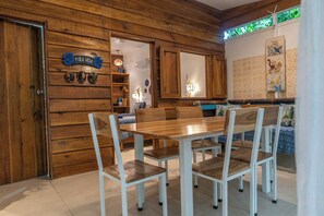 Un intérieur en bois comprenant une table et des chaises, un coin cuisine et un panneau décoratif.