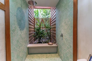 Un couloir étroit avec un banc, une porte en bois et une petite fenêtre.