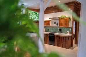 Une cuisine avec des meubles de rangement en bois, une cuisinière et une machine à café.
