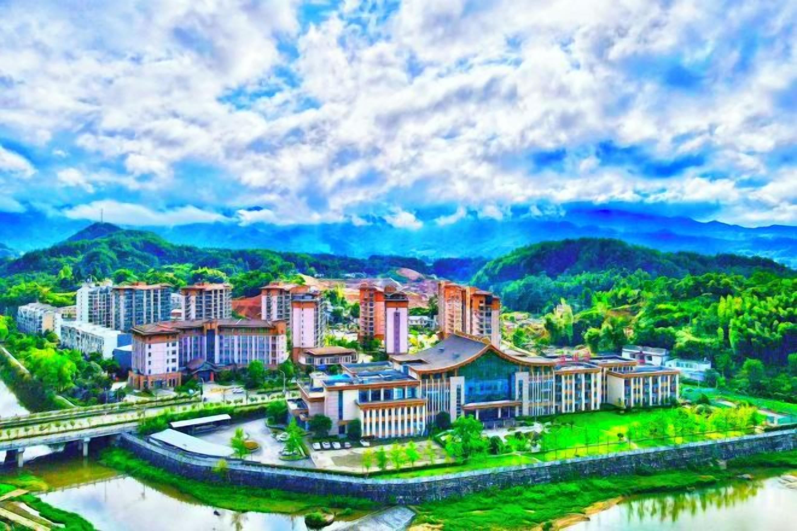 A residential complex with multiple buildings, a river, and surrounding greenery.