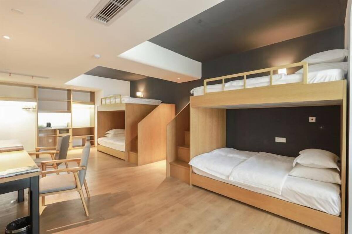 Een moderne hotelkamer met stapelbedden, een bureau en een stoel.