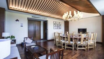 A dining area with a wooden ceiling, a chandelier, and a dining table surrounded by chairs.