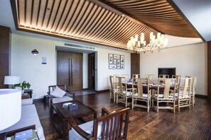 Un espace repas doté d’un plafond en bois, d’un lustre et d’une table à manger entourée de chaises.