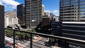 A cityscape with modern high-rise buildings, a clear sky, and a street with vehicles. - Lovely Relaxing-1 Bedroon 703 Condo (Cape Town)