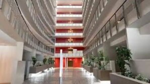 Um átrio amplo com pé direito alto, vários andares e área central aberta.