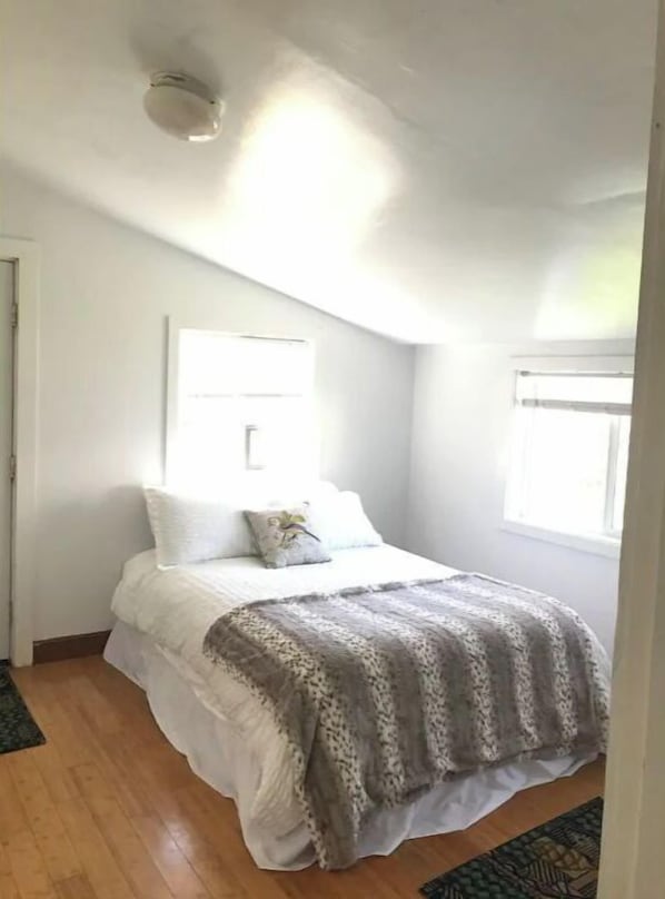 Un dormitorio con cama, ventana y puerta.