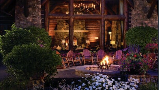 A log cabin with a stone facade, a fireplace, and outdoor seating. - Beaver Creek Luxury 2BR, 2Bath ski-in & ski-out suite inside the Ritz-Carlton (Beaver Creek)