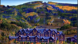 A lodge with multiple log cabins, surrounded by autumn-colored trees and a hilly landscape. - Beaver Creek Luxury 2BR, 2Bath ski-in & ski-out suite inside the Ritz-Carlton (Beaver Creek)