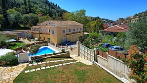 Una propiedad residencial con piscina, sendero de piedra y vistas a las colinas circundantes.
