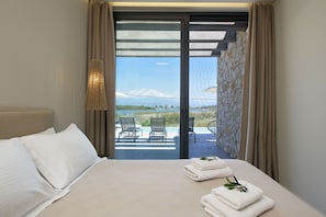 Enjoy breathtaking views of the surrounding mountains and water from the balcony, featuring a comfortable bed and seating area.