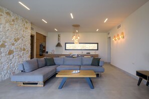 Relax in this stylish living space with a large L-shaped sofa, wooden coffee table, and modern pendant light.