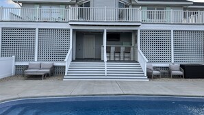 A two-story house with a balcony, a covered porch, and a swimming pool. - OBX ~ Ocean Views ~ Private Pool ~ Golf Course ~ (Kitty Hawk)
