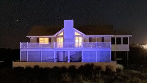 A modern house with a flat roof, large windows, and a balcony. - OBX ~ Ocean Views ~ Private Pool ~ Golf Course ~ (Kitty Hawk)