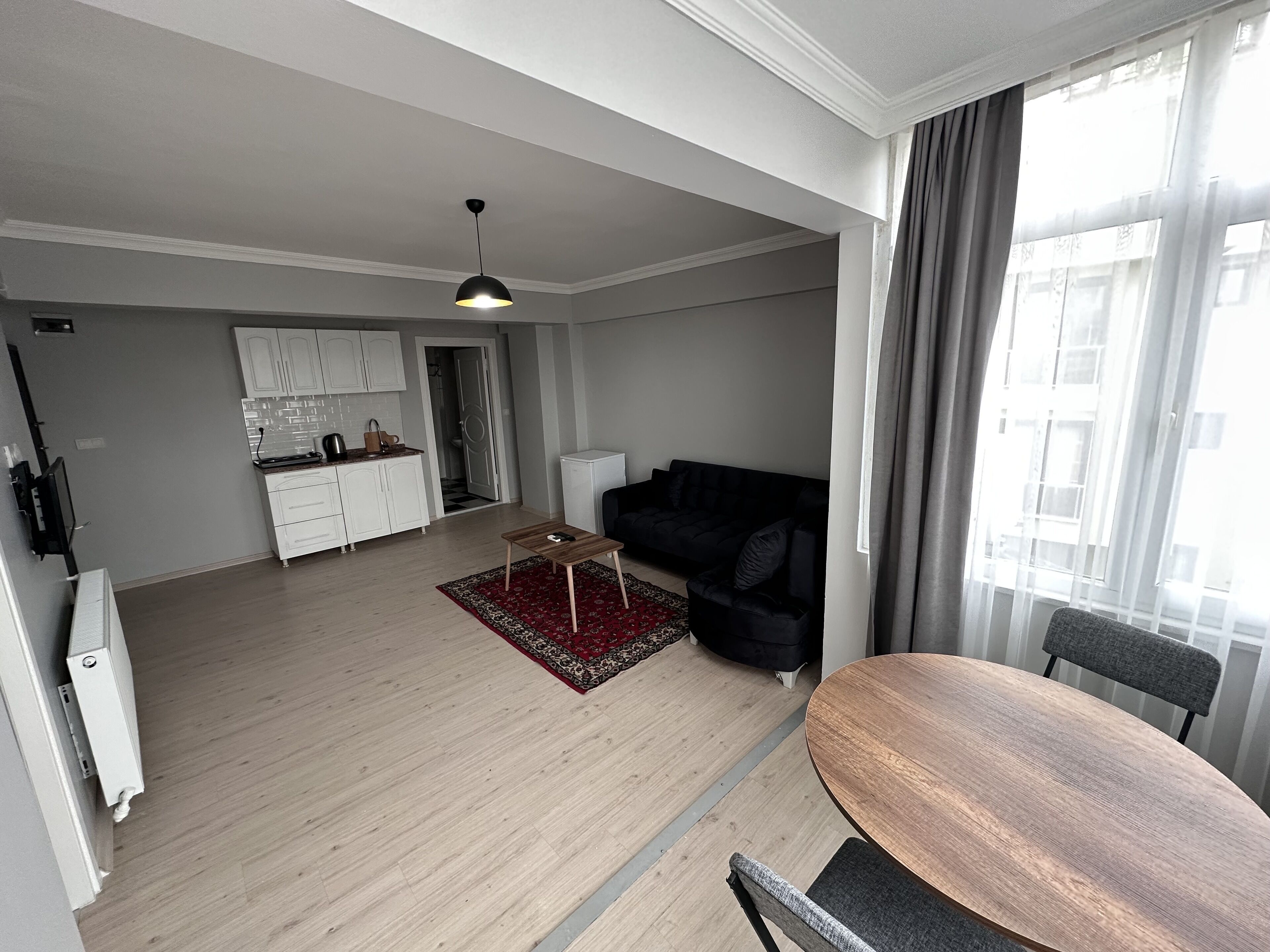 A modern apartment with a kitchen, living room, and dining area.