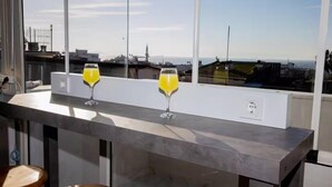 A modern bar with two glasses of orange juice on a counter, overlooking a cityscape. - Asparagus Hotel Suits Old City (Istanbul)