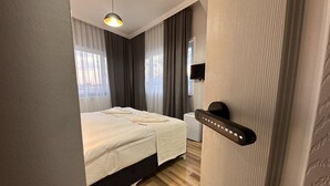 A modern hotel room with a bed, a desk, and a television. - Asparagus Hotel Suits Old City (Istanbul)
