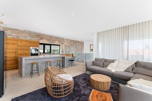 A modern living space with a kitchen, bar area, and seating area. - Villa Flying Star with Pool (Premantura)