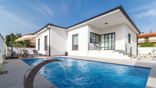 A modern house with a swimming pool, a covered patio, and a staircase leading to the upper floor. - Villa Lotus with Heated Pool (Pula)