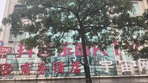 A building with a large sign in red characters, a tree in front, and a modern glass facade. - 168 Business Hotel (Jinjiang)
