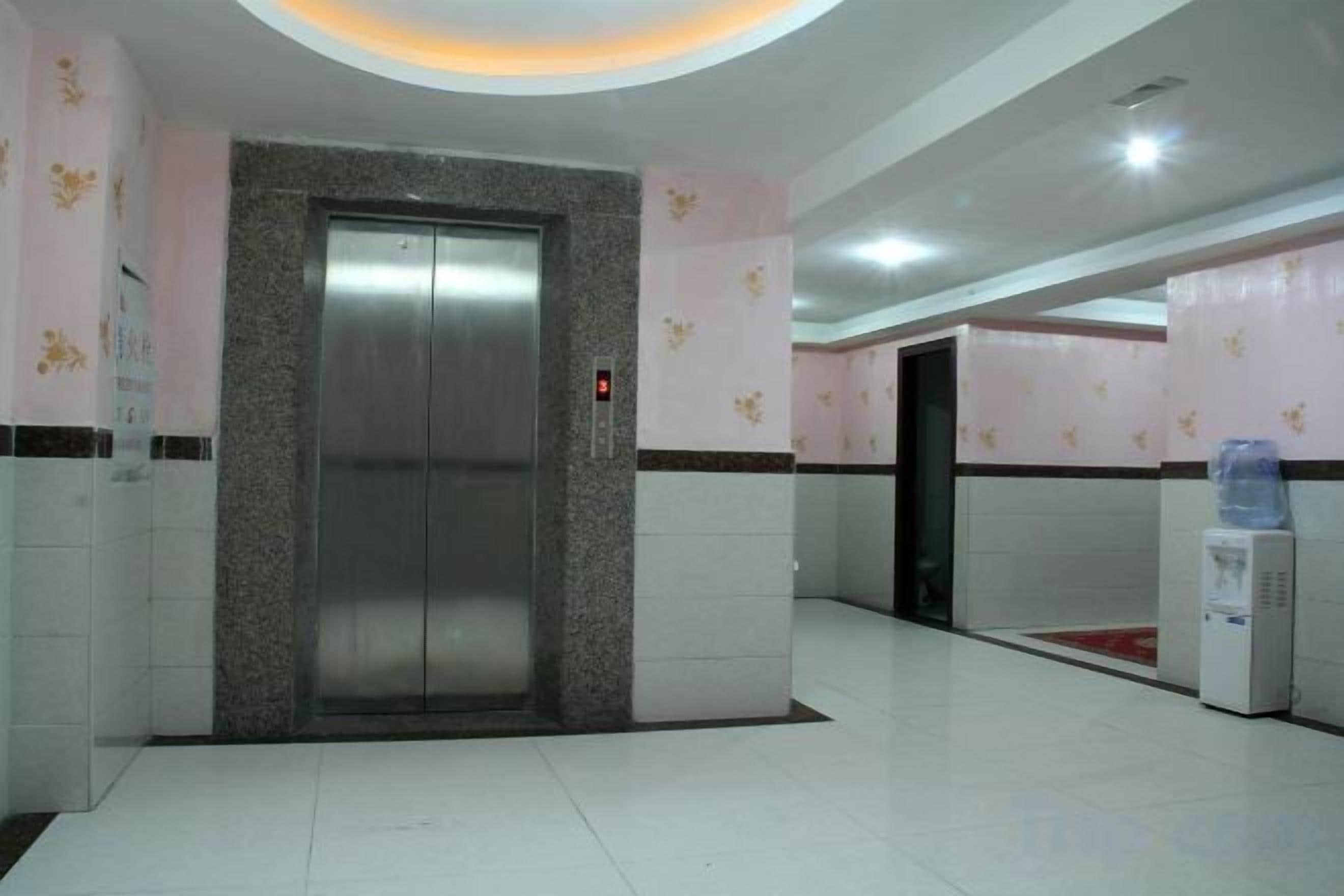 An elevator in a lobby with a water dispenser nearby.
