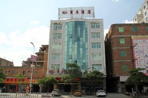 A multi-story hotel with a curved facade, signage indicating it is a hotel, and a visible entrance with a covered walkway. - 168 Business Hotel (Jinjiang)