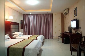 A hotel room with two beds, a desk with a computer, a chair, a television, and an air conditioning unit. - 168 Business Hotel (Jinjiang)