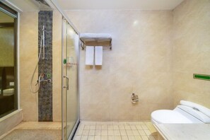 Ein Badezimmer mit Duschkabine aus Glas, Toilette und Waschbecken.