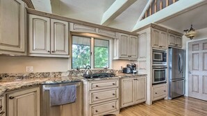 A spacious kitchen with granite countertops, stainless steel appliances, and light wood cabinetry. - Large Lake House: Expansive View (Paw Paw)